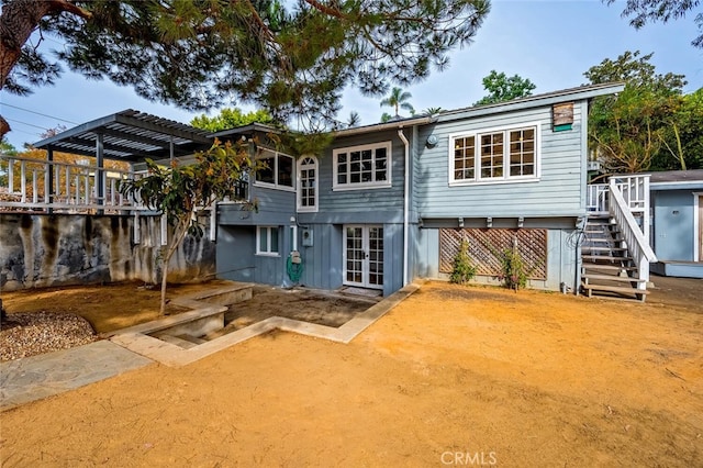 rear view of house with french doors and a pergola