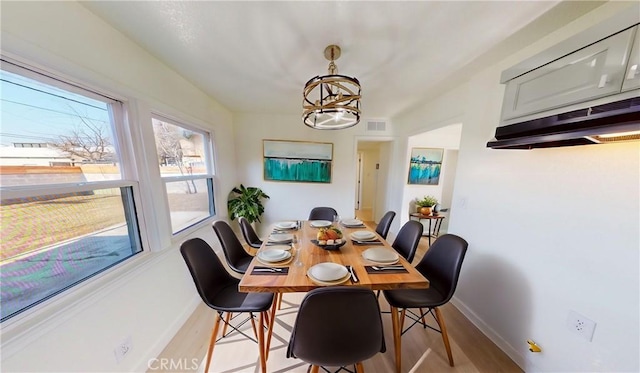 dining area featuring an inviting chandelier and light hardwood / wood-style flooring