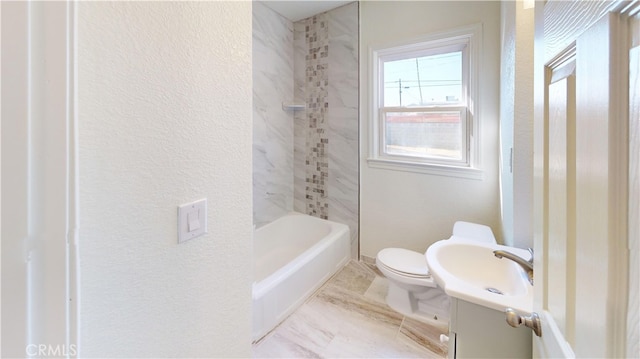 full bathroom with tiled shower / bath, vanity, and toilet