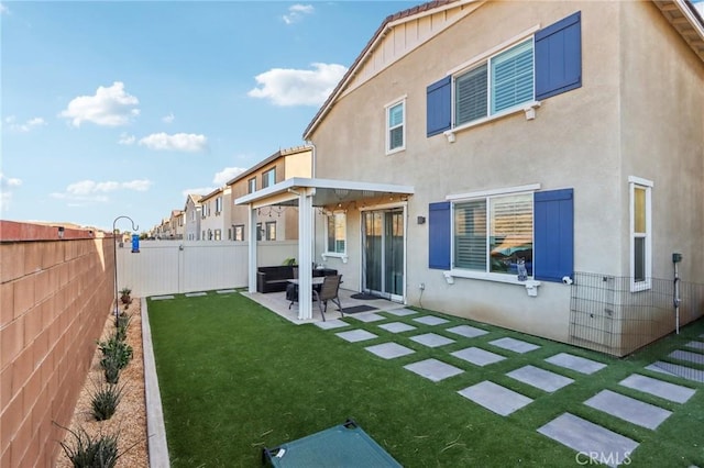 back of property with a lawn and a patio area