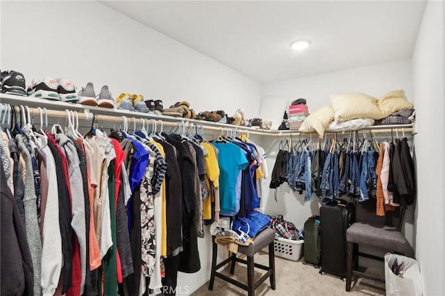 walk in closet featuring light colored carpet