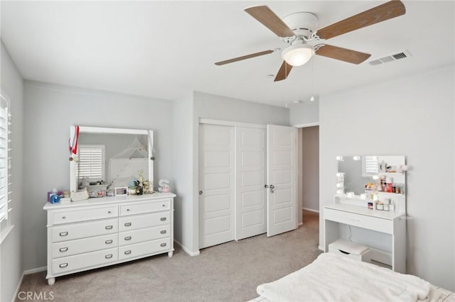 carpeted bedroom featuring ceiling fan and a closet