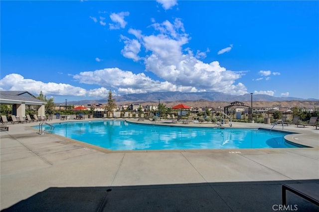 view of swimming pool featuring a mountain view and a patio area