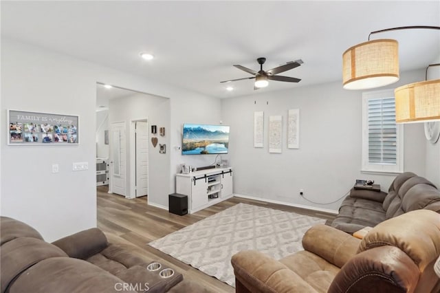 living room featuring ceiling fan and light hardwood / wood-style floors