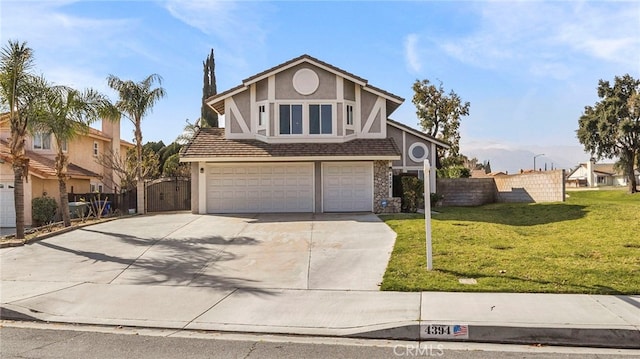 tudor-style house with an attached garage, fence, driveway, stucco siding, and a front yard