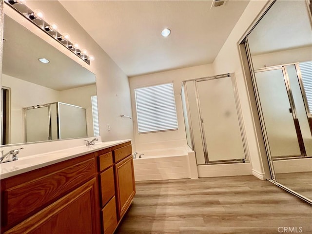 bathroom with vanity, hardwood / wood-style floors, and plus walk in shower