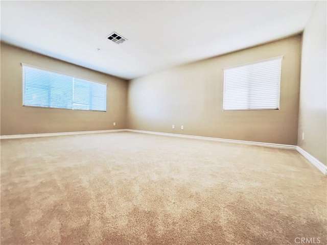 spare room featuring light carpet