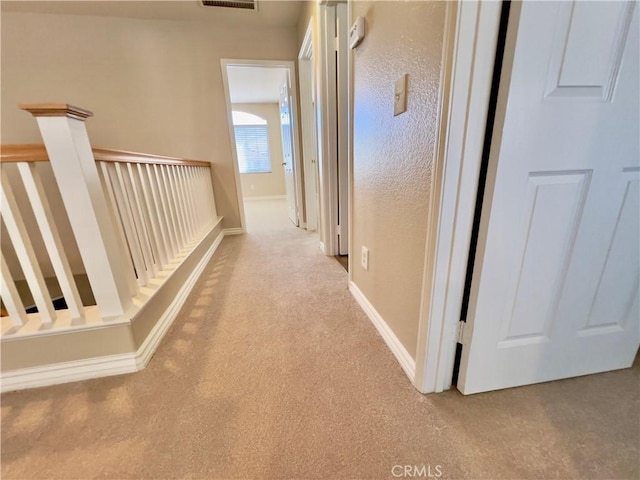 corridor featuring light colored carpet