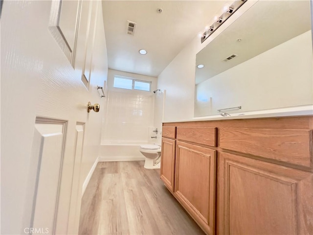 full bathroom featuring vanity, hardwood / wood-style floors, toilet, and shower / bath combination