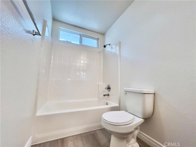 bathroom featuring bathing tub / shower combination, wood-type flooring, and toilet