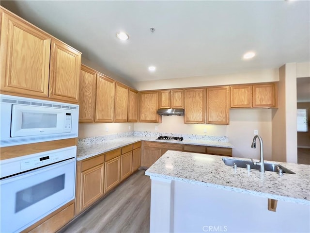 kitchen featuring sink, white appliances, light hardwood / wood-style floors, and light stone countertops