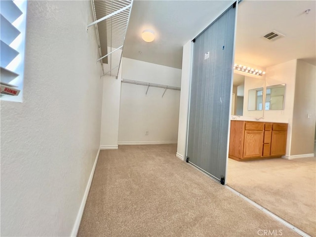 walk in closet featuring light carpet