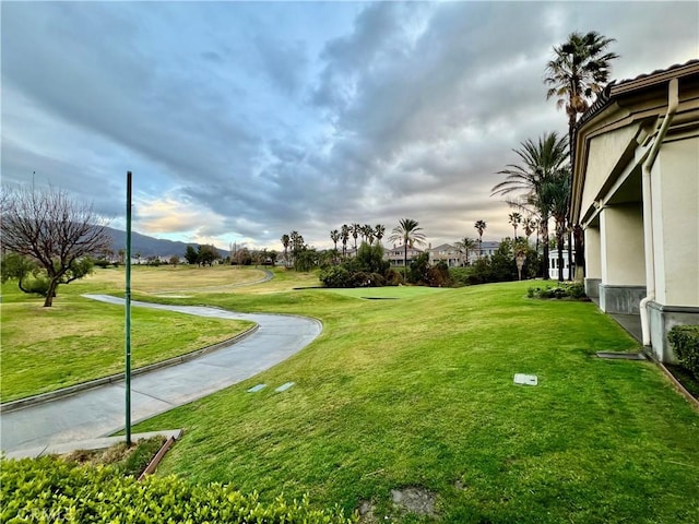 surrounding community with a mountain view and a lawn