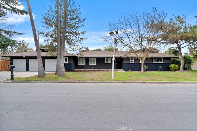 ranch-style home featuring a garage and a front lawn