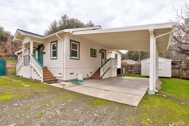 view of front of home with a front yard, a patio area, and a storage unit