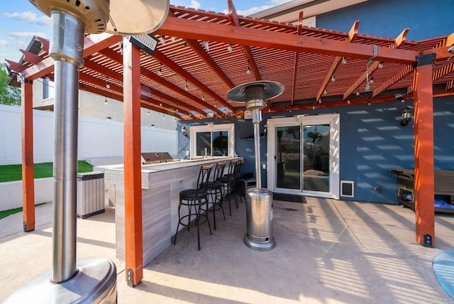 view of patio / terrace with a bar, a grill, and a pergola