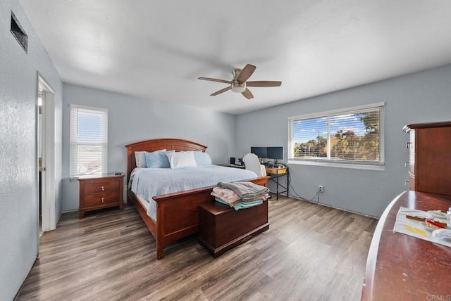 bedroom with dark hardwood / wood-style floors and ceiling fan