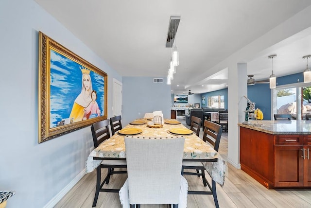 dining space with ceiling fan and light wood-type flooring