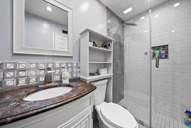 bathroom with vanity, a shower with door, and toilet