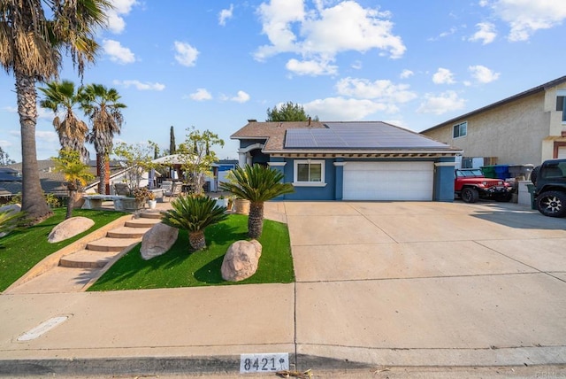 view of front of property featuring a garage and solar panels