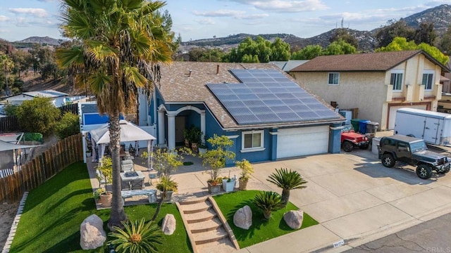 view of front facade with a mountain view and solar panels