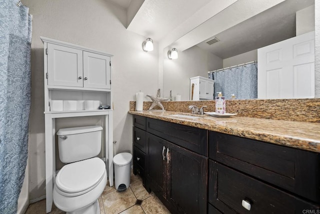 bathroom featuring vanity, tile patterned flooring, toilet, and walk in shower