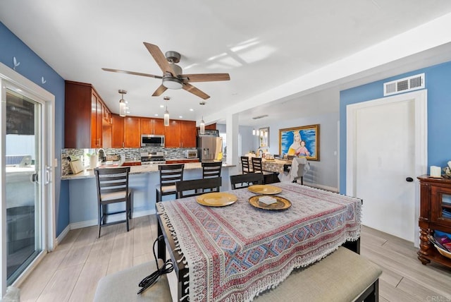 dining area with ceiling fan and light hardwood / wood-style floors