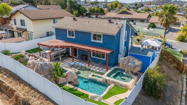 rear view of property featuring a pool with hot tub and a patio