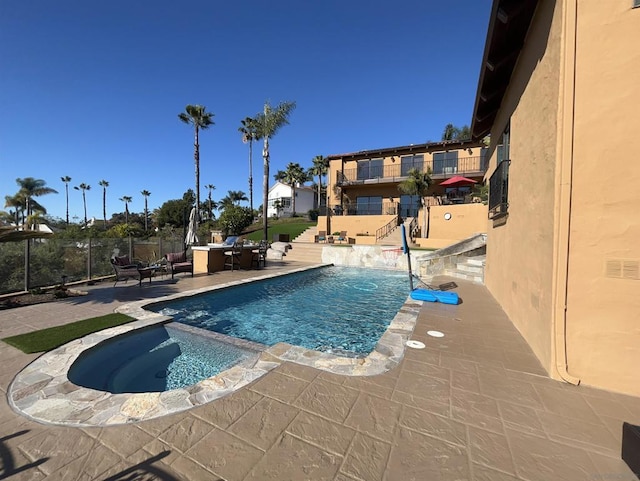 view of swimming pool featuring an in ground hot tub and a patio area