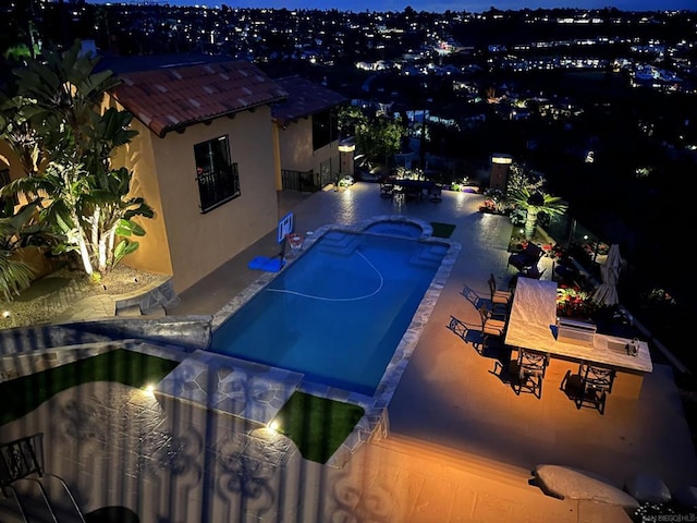 pool at twilight with a patio