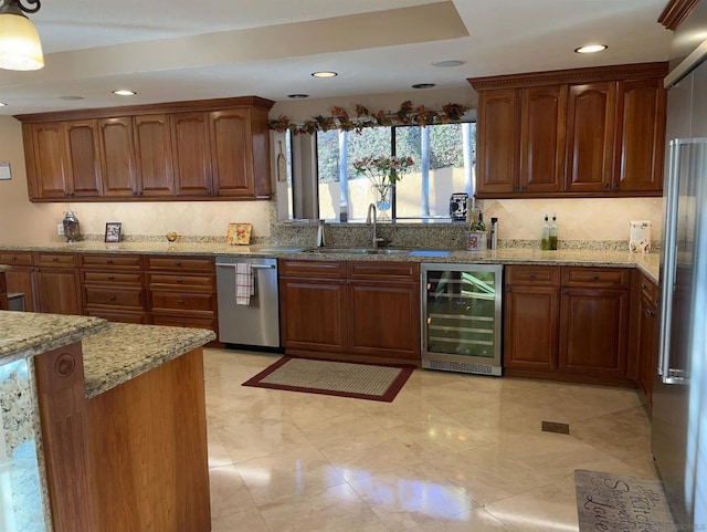 kitchen with appliances with stainless steel finishes, sink, backsplash, beverage cooler, and light stone counters