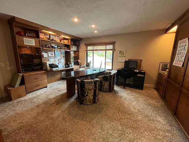 carpeted home office with a textured ceiling