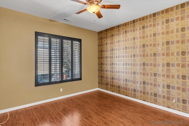 empty room with wood-type flooring and ceiling fan