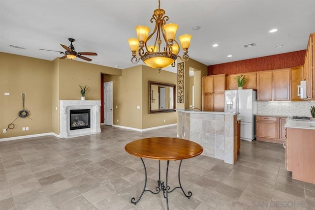 kitchen featuring white appliances, ceiling fan, hanging light fixtures, backsplash, and a center island