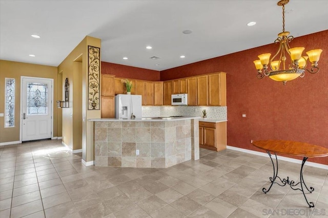 kitchen featuring white appliances, a center island, a notable chandelier, decorative backsplash, and decorative light fixtures