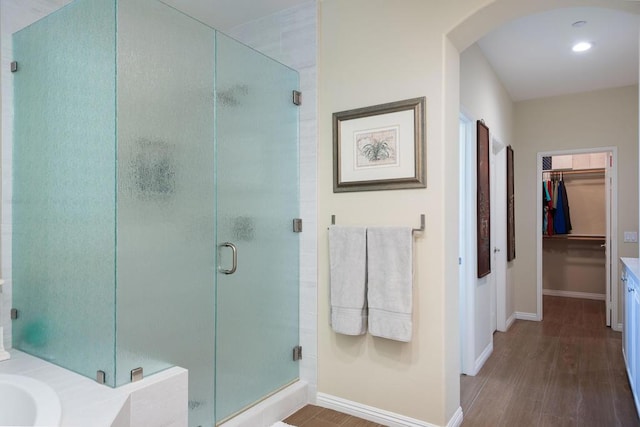 bathroom with vanity, a shower with shower door, and hardwood / wood-style floors