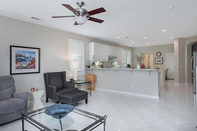 tiled living room with ceiling fan