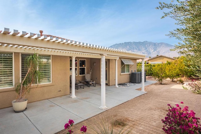 rear view of house featuring a patio, a mountain view, and central AC unit