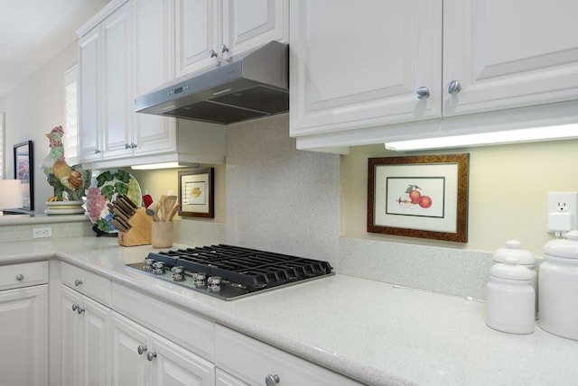 kitchen with stainless steel gas stovetop and white cabinetry