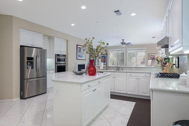 kitchen featuring white cabinetry, ventilation hood, light tile patterned floors, appliances with stainless steel finishes, and a kitchen island