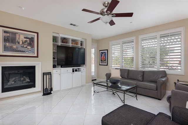 living room featuring light tile patterned flooring, ceiling fan, and built in features