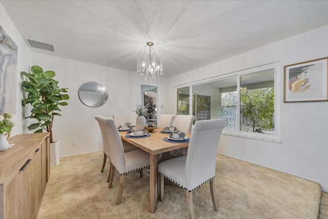 carpeted dining area featuring a chandelier