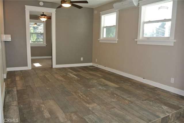 empty room featuring ceiling fan, plenty of natural light, an AC wall unit, and dark hardwood / wood-style flooring