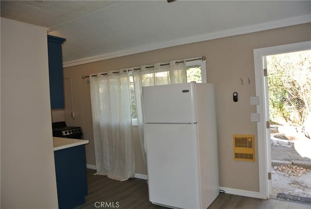 kitchen with white refrigerator, crown molding, dark hardwood / wood-style floors, and heating unit