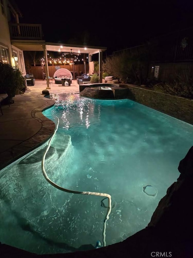 pool at twilight featuring a patio area