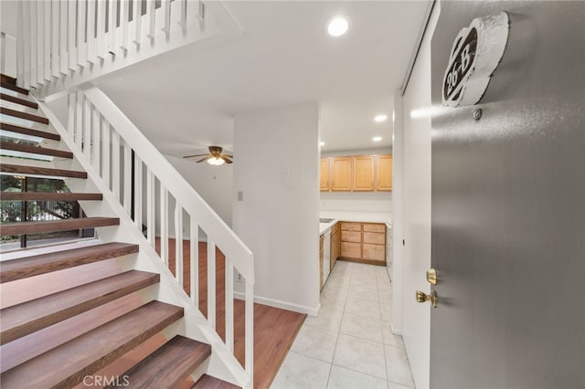 stairs featuring ceiling fan and tile patterned floors