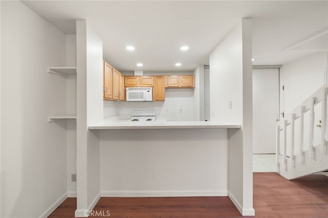 kitchen featuring wood-type flooring, light brown cabinetry, and stove