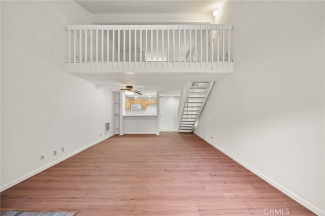 unfurnished living room with ceiling fan and light hardwood / wood-style flooring