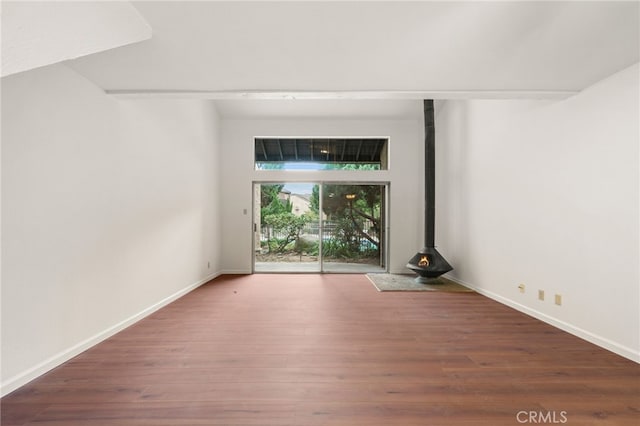 empty room featuring hardwood / wood-style floors and a wood stove