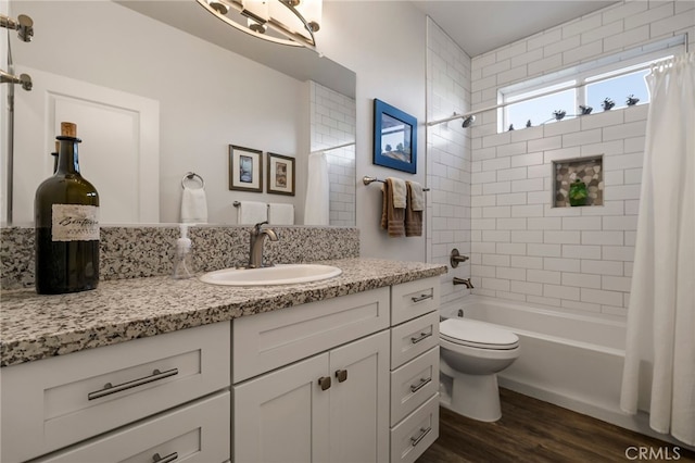 full bathroom with hardwood / wood-style flooring, vanity, shower / tub combo with curtain, and toilet